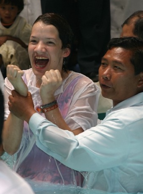 a young woman is filled with joy at baptism
